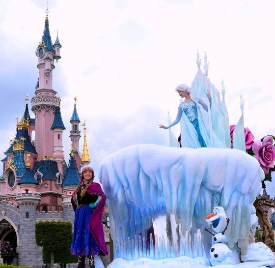 Elsa, arriba en la carroza, su hermana Anna y el muñeco de nieve Olaf, los tres personajes de 'Frozen', durante el desfile en Disneyland Paris.