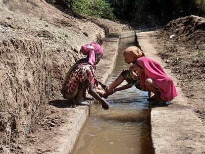 Niñas en un canal que riega cultivos en una comunidad rural en Etiopía, mediante paneles solares que ayudan a bombear el agua.