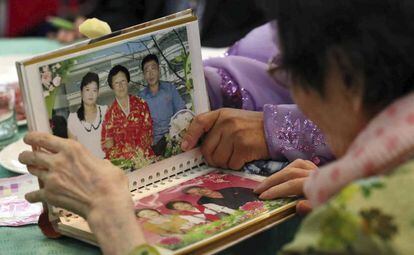 Una familia observa una fotografías durante el reencuentro de parientes de Corea del Norte y Corea del Sur.
