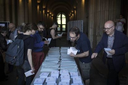 Varias personas escogen papeletas en el colegio electoral de Universitat de Barcelona.
