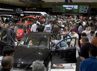 El primer día del Salón del Automóvil registró ya una gran presencia de ciudadanos, como se aprecia en la fotografía superior, con un pabellón de Seat a rebosar, y en la fotografía de abajo, en la que un grupo de jóvenes se interesa por las condiciones y cualidades de un modelo de la casa japonesa Honda.