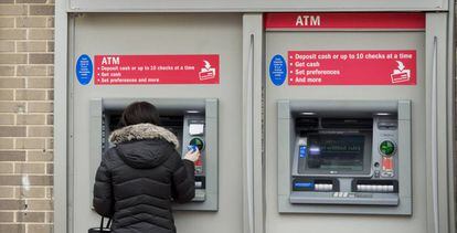 Una clienta retirando dinero de un cajero automático