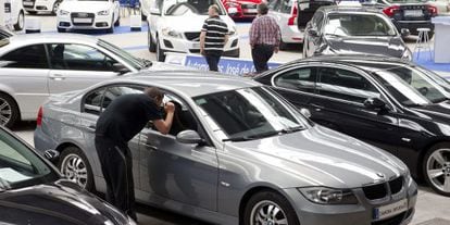 Varias personas observan un coche. 