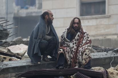 Dos hombres, sentados sobre los escombros de un edificio en Jandaris, Siria. 