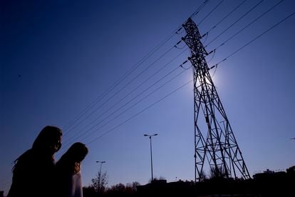 Two women walk near a power line pole in Seville, in a file image.