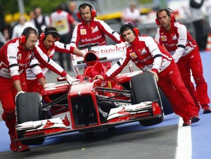 Los mec&aacute;nicos de Ferrari empujan el coche de Alonso.