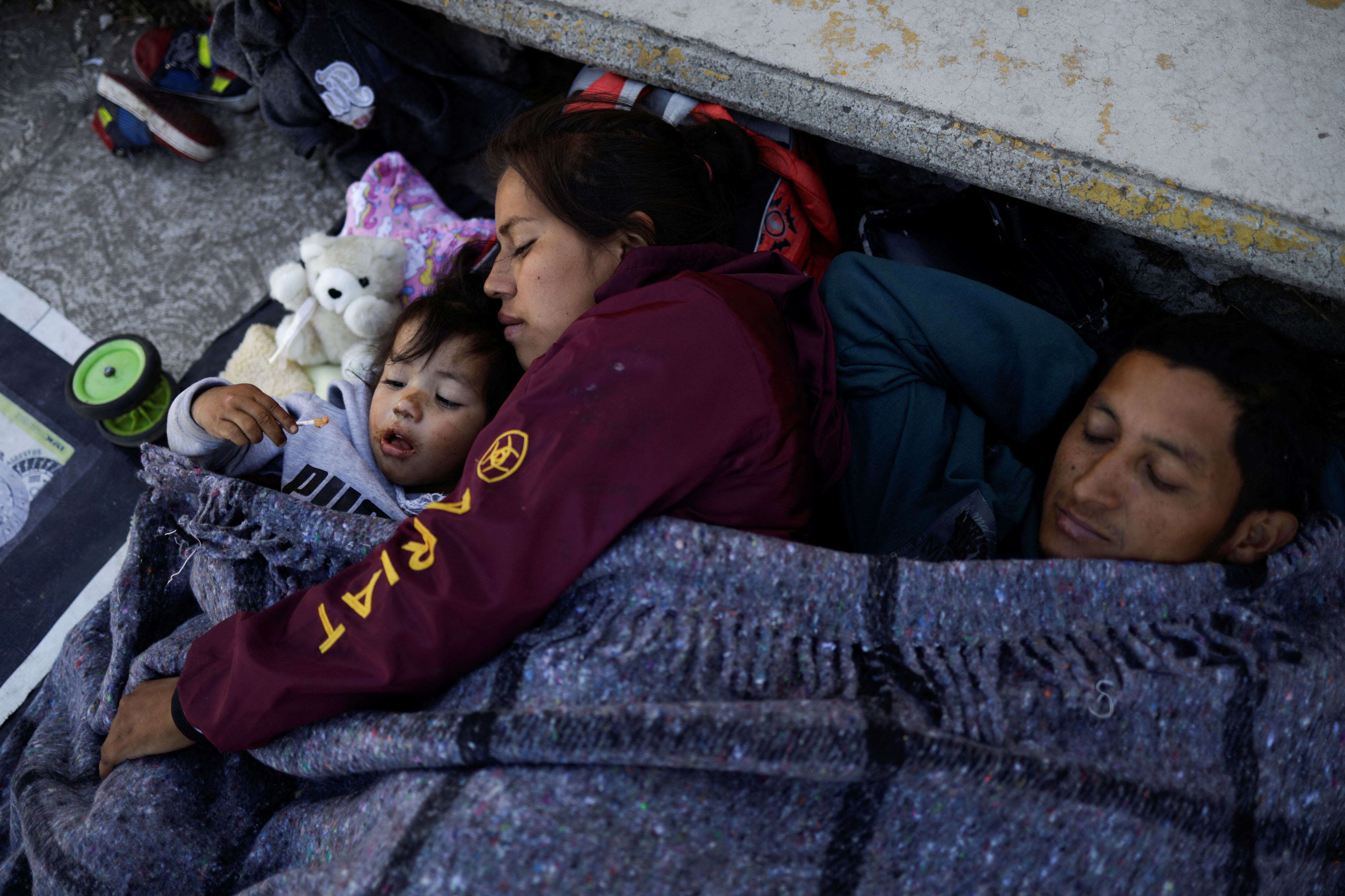 Una familia migrante descansa mientras participa en una caravana que se dirige a la Ciudad de México, en Río Frío de Juárez, México.