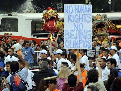 Un atleta porta la llama olímpica entre manifestantes contra China ayer en Buenos Aires.