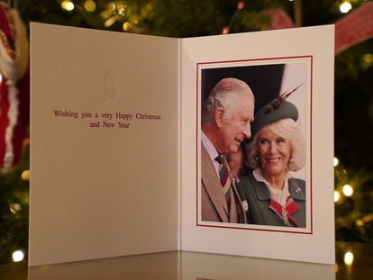 La tarjeta navideña de 2022 del rey Carlos III y la reina consorte Camila, tomada durante los Juegos de Braemar el 3 de septiembre de 2022, se exhibe frente a un árbol de Navidad en Clarence House en Londres.