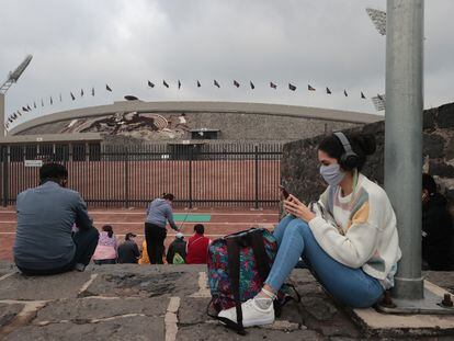 Una mujer hace uso de su teléfono celular afuera del Estadio Olímpico Universitario, en Ciudad de México.