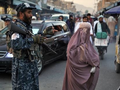 Una mujer, junto a un militar talibán, en el centro de Kandahar (Afganistán).