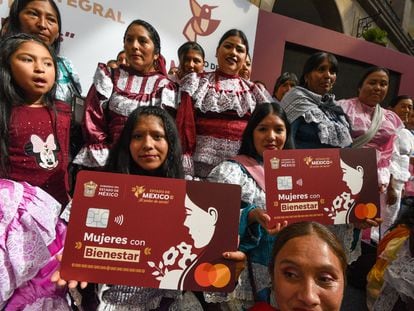 Mujeres muestran tarjetas a gran escala del plástico del programa 'Mujeres con bienestar', en Toluca, el 20 de noviembre.