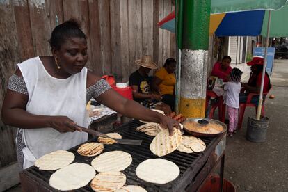 Una mujer prepara arepas en un puesto ambulante en las calles del casco urbano del pueblo.