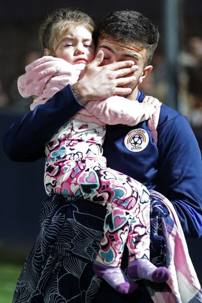 Un hombre se limpia los ojos mientras sostiene a su hija en el interior del estadio. La muerte del hombre, un seguidor de Gimnasia llamado Carlos Regueiro, fue confirmada por el mismo ministro de Seguridad, Sergio Berni. “Falleció cuando salía del estadio por un paro cardíaco”. 