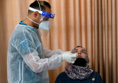 Un sanitario palestino toma una muestra a una mujer para hacerle un test de coronavirus en el municipio de Dura, Cisjornadia, el 8 de enero.