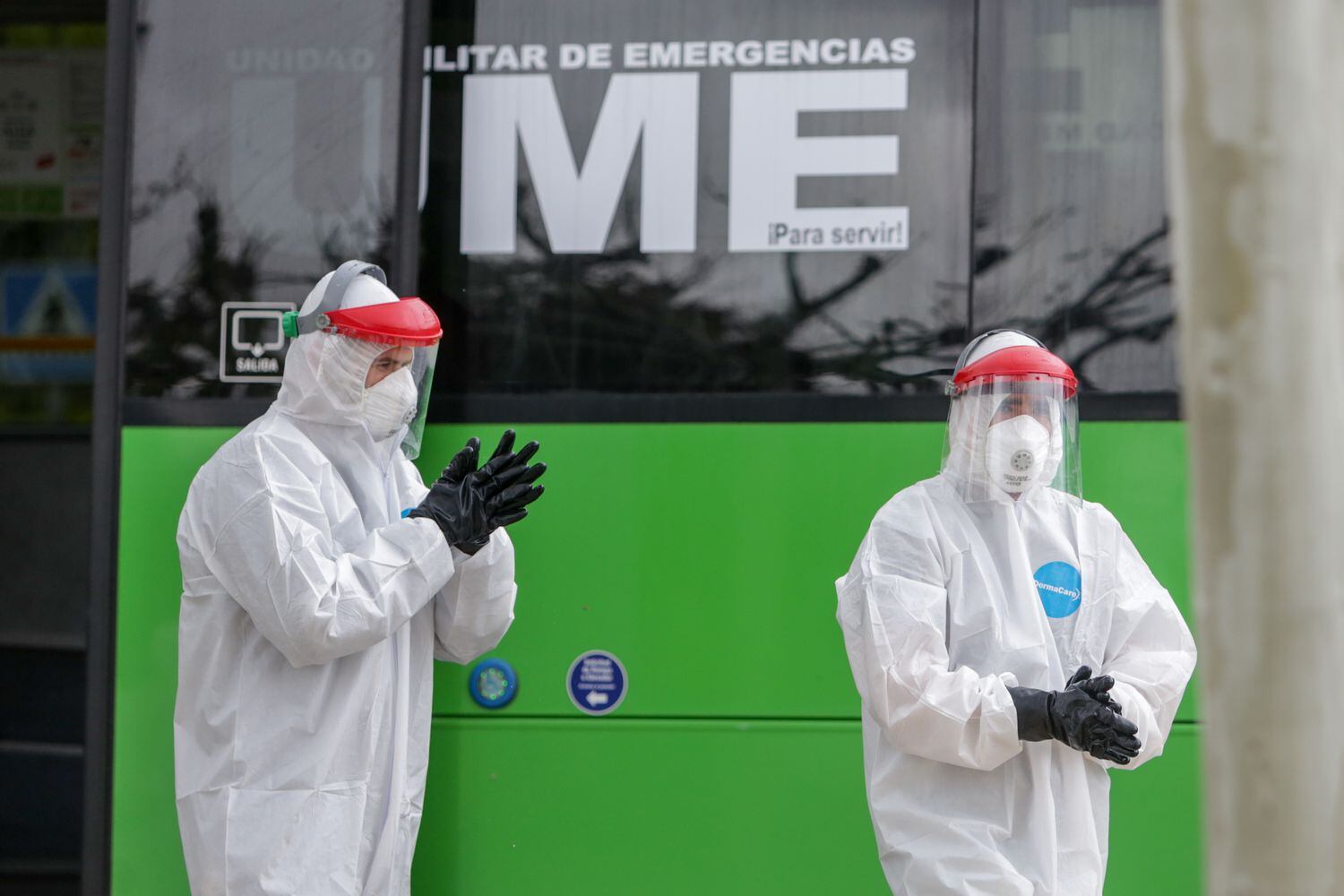 Dos policías militares al lado de uno de los autobuses cuyos pasajeros son pacientes contagiados con coronavirus que van del Hospital 12 de Octubre hacia el Hospital de Campaña de IFEMA