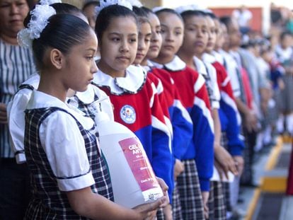 Una niña sostiene un bote de gel antibacterial en una escuela de Nuevo León, México.