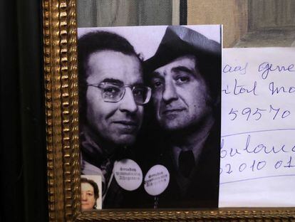 Ferlosio, a la derecha, con su amigo Agustín García Calvo, en una fotografía colocada sobre un cuadro de su casa. En la solapa llevan la chapa que ellos mismos fabricaron para uno de sus coloquios sobre gramática. Superpuesta, fotografía de su viuda, Demetria Chamorro.