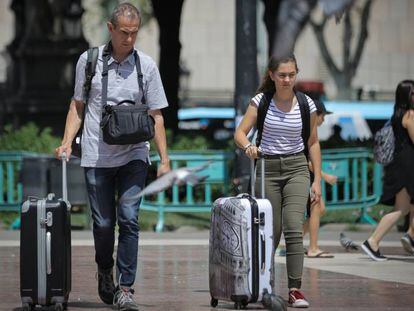 Turistas con maletas por el centro de Barcelona.