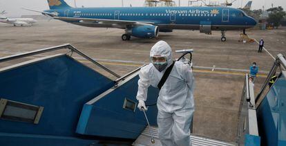 Trabajadores desinfectan un avión en Hanoi, Vietnam. 