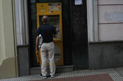Un cliente saca dinero en un cajero de CaixaBank