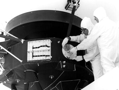 Dos ingenieros instalan el disco dorado en la sonda Voyager, en una imagen de archivo de 1977.