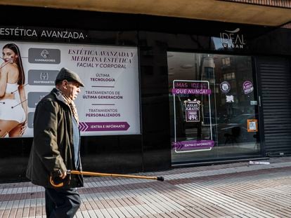 Un hombre camina delante de un establecimiento cerrado de Centros Ideal en el centro de Madrid.