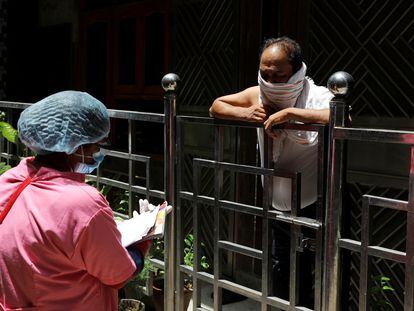 Un trabajador comunitario de la salud empleado por el Ministerio de Sanidad de la India realiza una encuesta puerta a puerta sobre la incidencia de la covid-19 en Nueva Delhi, India, el 26 de junio de 2020.