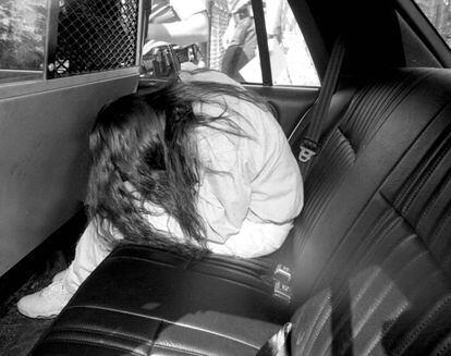 Amy Fisher oculta su rostro de la prensa en un coche de polic&iacute;a en junio de 1992.