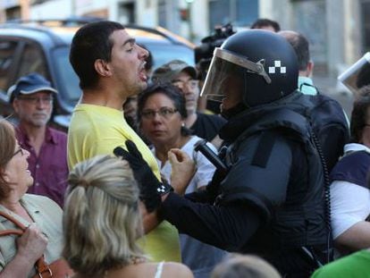 Un polic&iacute;a discute con un vecino que se opone al desalojo de una vivienda de la calle de Ofelia Nieto de Madrid, el pasado agosto.