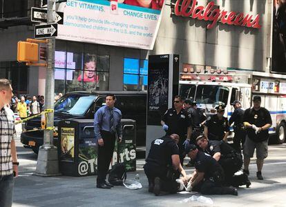 Policías ayudan a los heridos después de que un vehículo atropellase a peatones en una acera en Times Square, Nueva York.
