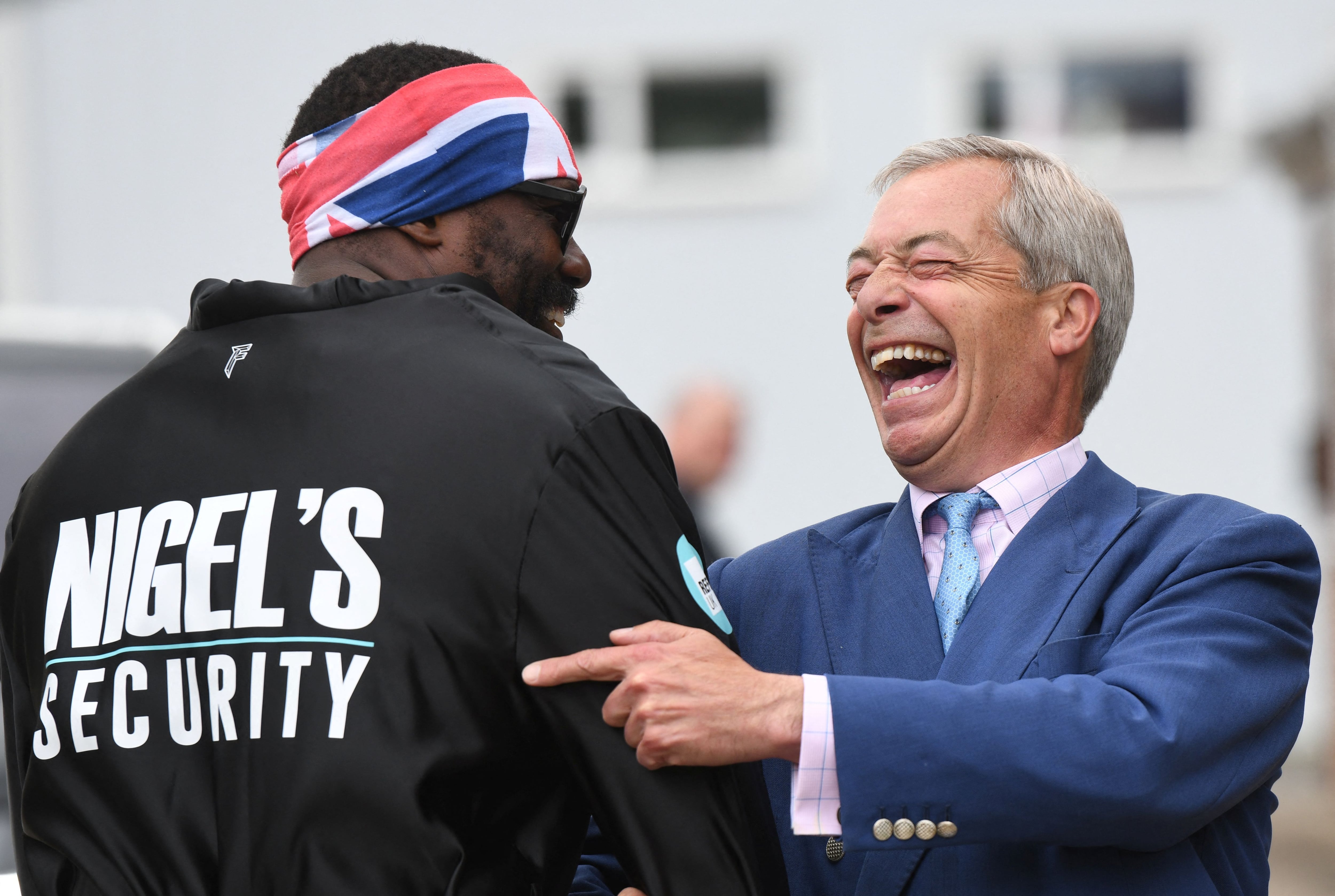 Britain's Reform UK Party Leader Nigel Farage poses with heavyweight boxer Derek Chisora, near a boxing gym, during a campaign visit in Clacton, Britain, July 3, 2024. REUTERS/Chris J. Ratcliffe