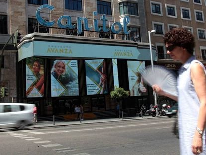 Una mujer pasa por delante del cine Capitol, abanico en mano.