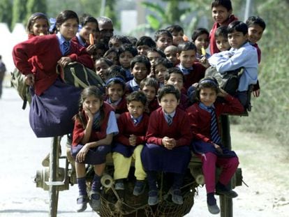 Más de 35 niños vuelven de la escuela subidos en un carro en las afueras de Nueva Delhi.