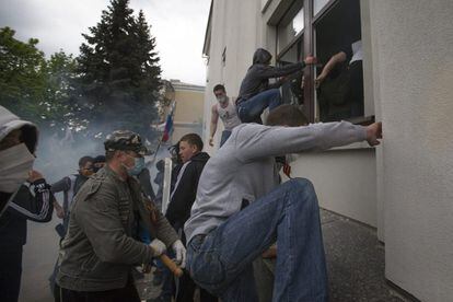 Cientos de separatistas pro rusos han irrumpido en la sede del gobierno regional en la ciudad de Lugansk, en el este de Ucrania, tras romper las ventanas y no encontrarse con resistencia por parte de la Policía. En la imagen, activistas pro rusos entran en la sede del Gobierno de Lugansk (Ucrania).