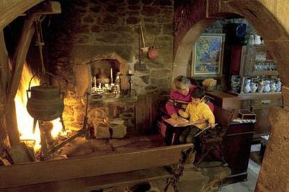 Una abuela con su nieto en la lareira de la rectoral de San Andrés de Sarandón (Vedra) construida a finales del siglo XV.