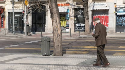 Un hombre pasa frente a multitud de comercios cerrados en Madrid.