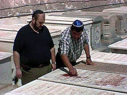 Dos miembros de la comunidad israelí de Melilla examinan las pintadas.