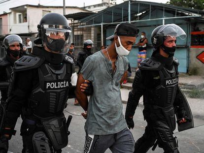 Dos policías llevan detenido a un hombre durante las protestas contra el Gobierno cubano en La Habana, este lunes.
