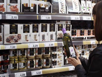 Una mujer compra una botella de aceite oliva extra en un supermercado de Madrid.