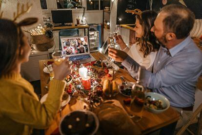 Una familia celebra una cena de Navidad por medio de una videollamada.
