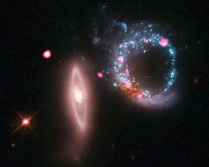 Imagen compuesta de observaciones captadas con los telescopios <i>Hubble</i> y <i>Chandra</i> de los efectos de una colisión galáctica: a la derecha se aprecia un anillo azulado residual de una galaxia, en el que hay estrellas neutrones y posibles agujeros negros, y a la izquierda, el resto del otro conjunto galáctico.