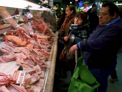 Varias personas esperan su turno en una carnicería del Mercado de Maravillas, en Madrid.