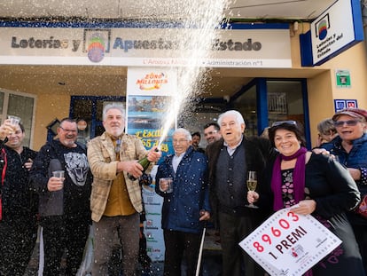 Los propietarios de la administración número 1 de L'Escala (Girona) celebran con agraciados y curiosos tras haber repartido todas las 40 series del primer premio de la Lotería de El Niño este viernes.