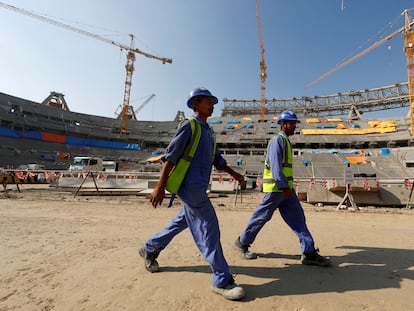 Dos trabajadores en el interior del estadio Lusail de Doha, Qatar, en diciembre de 2019. El recinto se ha construido para el campeonato mundial de fútbol de 2022, que se celebrará en esta ciudad.