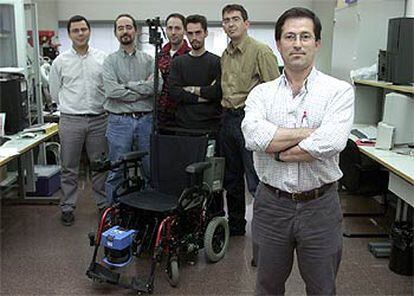 Javier González posa junto a la silla eléctrica robotizada y parte de su equipo detrás.