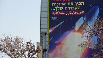 Una valla publicitaria que muestra misiles iraníes con un mensaje en persa y hebreo que dice: "preparad vuestros ataúdes", cuelga de un edificio en la plaza Palestina de Teherán, el lunes 16 de enero.