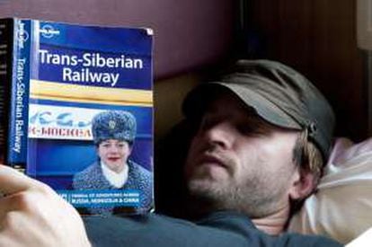 Un pasajero con una guía de viajes del Transiberiano.