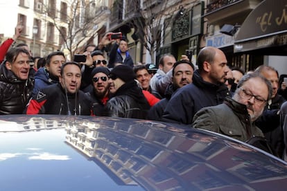 Javier Barbero (derecha) se introduce en un coche mientras es increpado por los asistentes a una concentración de policías municipales de Madrid.
