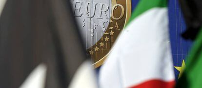 La insignia del euro tras varias banderas.